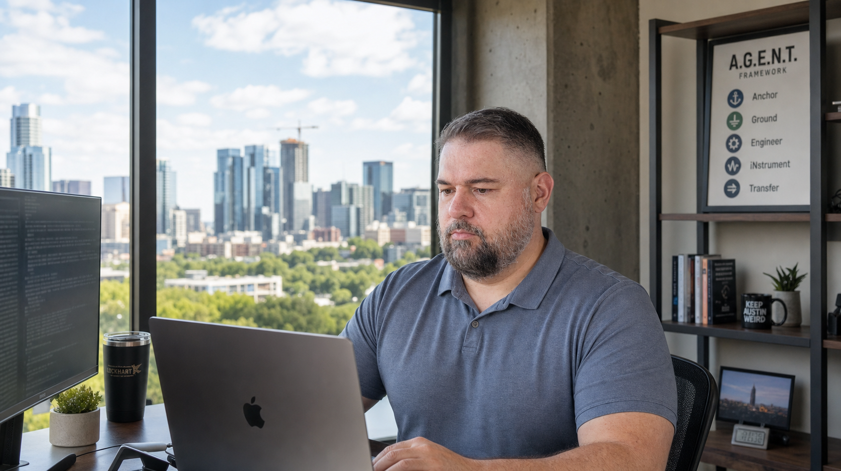 Andrew Korolov at his desk, with the A.G.E.N.T. framework poster on the wall behind him